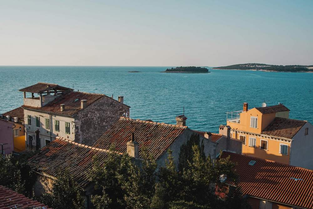 Pogled preko krovova na more i otočić